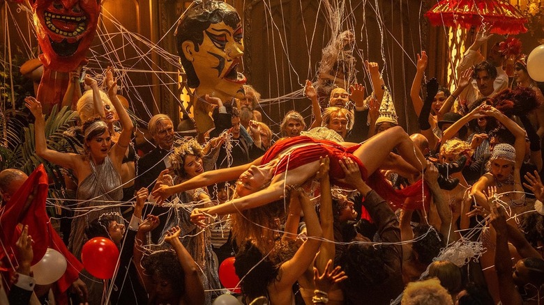 Margot Robbie as Nellie LaRoy being carried around at a party in Babylon