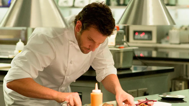 Adam bereidt een gerecht in Burnt
