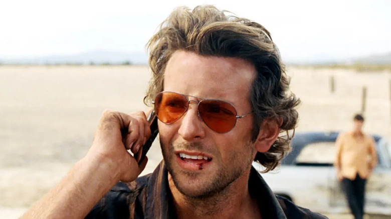 A ressaca, Bradley Cooper como Phil, conversando ao telefone com um lábio sangrento
