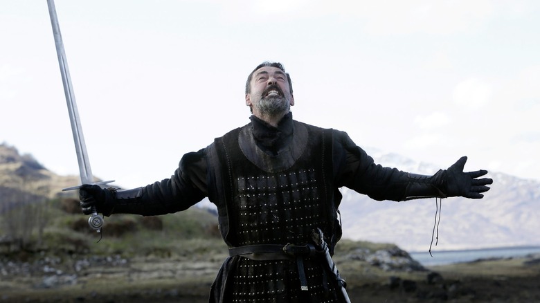Robert with a sword wailing into the sky in Robert the Bruce