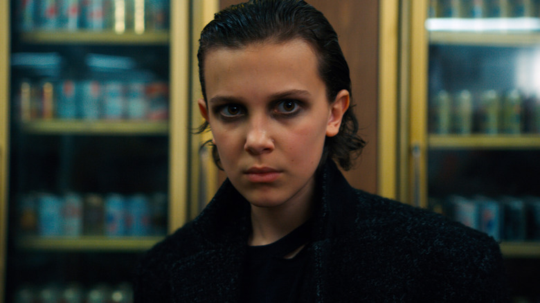 Eleven with slicked back hair and dark eye makeup in Stranger Things