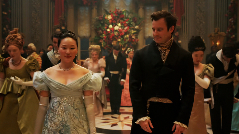 బ్రిడ్జర్టన్‌లోని ఒక హాలులో ల్యూక్ థాంప్సన్ యొక్క బెనెడిక్ట్ బ్రిడ్జర్టన్ పక్కన యెరిన్ హా యొక్క సోఫీ బేక్ నిలబడింది