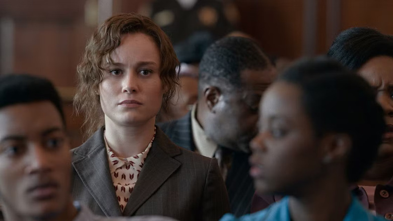 Brie Larson as Eva Ansley sitting in a courtroom audience in Just Mercy