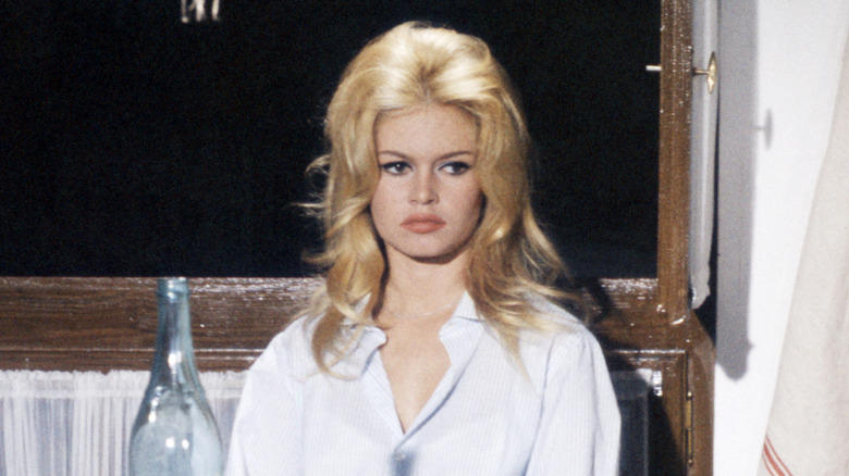 Brigitte Bardot zit aan tafel in een wit overhemd