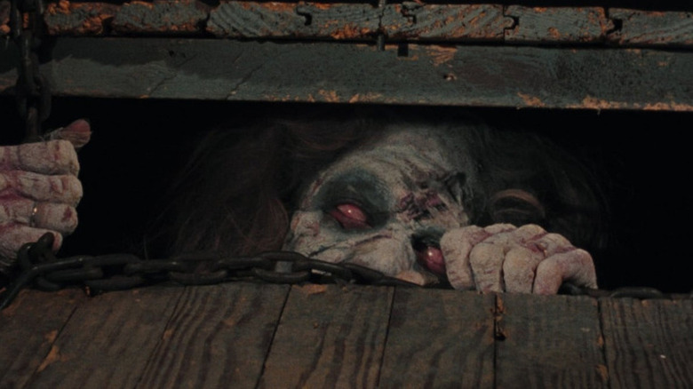 A Deadite peeking out from the cellar in The Evil Dead