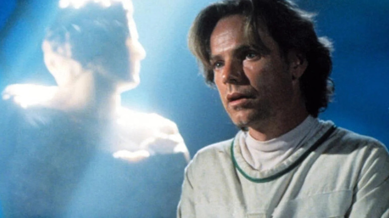 Thomas Veil in a straitjacket with an angelic figure behind him on Nowhere Man