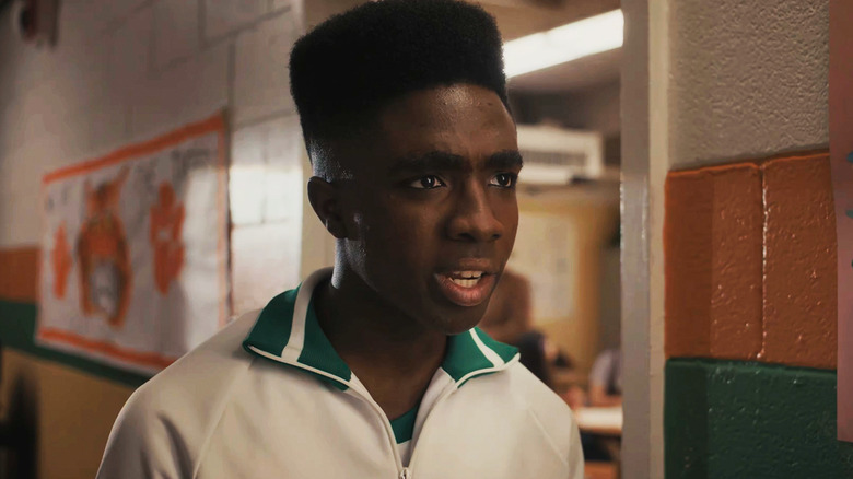 Caleb McLaughlin as Lucas Sinclair stands in a school hallway in Stranger Things