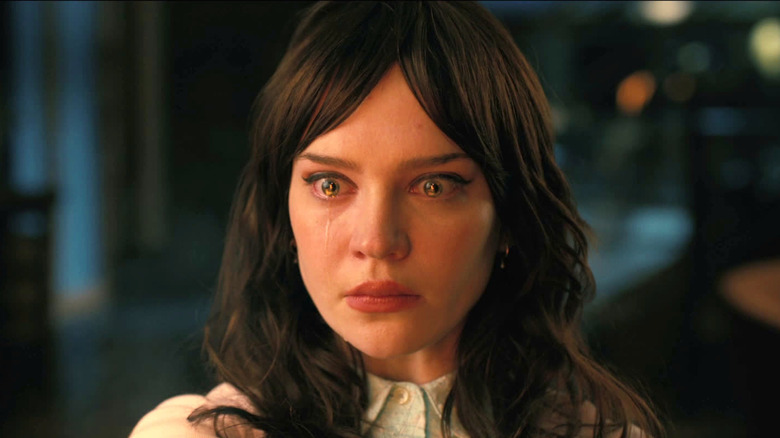Sophie Thatcher as Iris, crying at the dinner table in Companion