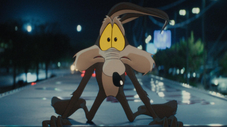 Wile E. Coyote riding on top of a truck in Coyote vs. Acme