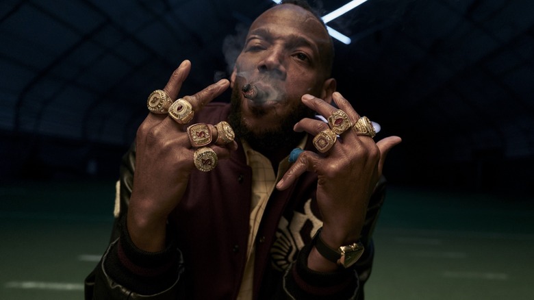 Marlon Wayans as Isaiah White holding up his eight rings with a beat up face in HIM