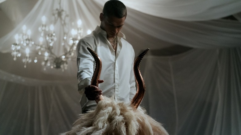 Tyriq Withers as Cameron Cole touching the goat head with the gold horns in HIM