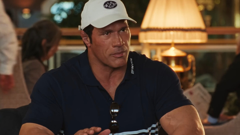 Dwayne Johnson as Mark Kerr sitting at a table in The Smashing Machine