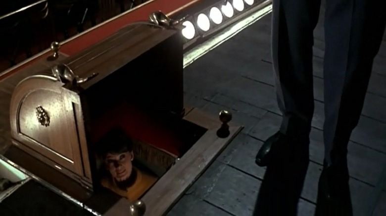Reggie hiding in a stage hole in Charade