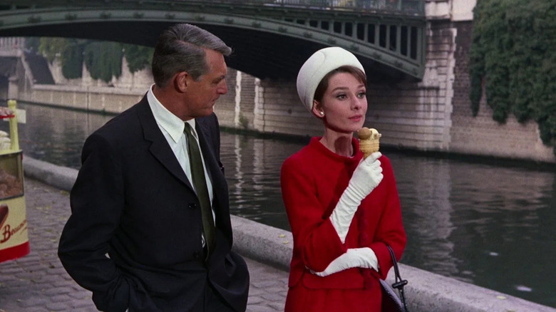 "Peter" and Reggie, walking by the Seine while she eats ice cream in Charade