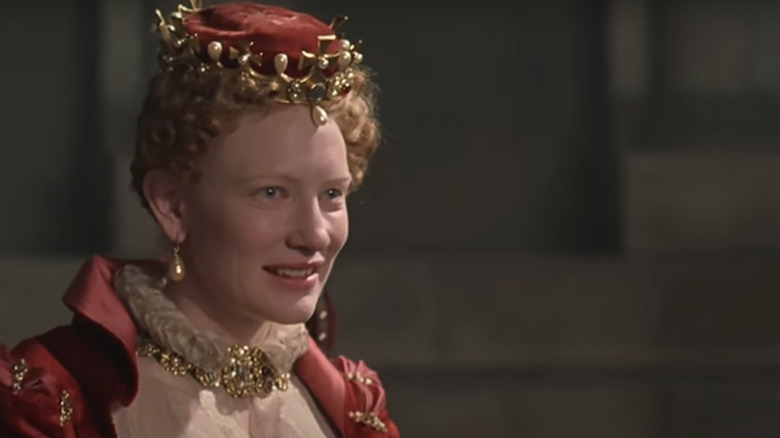 Cate Blanchett's Queen Elizabeth smiles as she looks across frame in Elizabeth