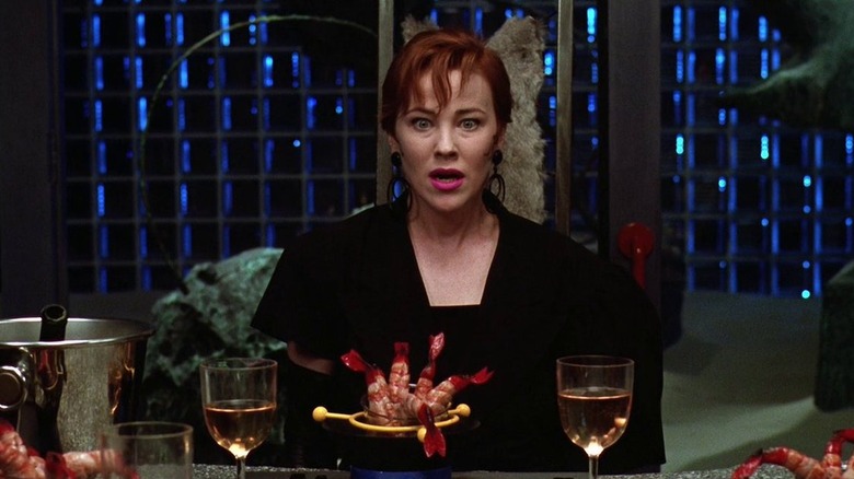 Catherine O'Hara as Delia Deetz sitting at the table looking shocked in Beetlejuice