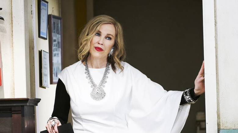 Moira wearing a white top in a doorway on Schitt's Creek
