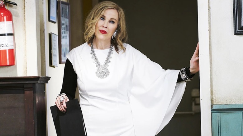 Catherine O'Hara, looking fabulous as Moira Rose, stands at a threshold in Schitt's Creek