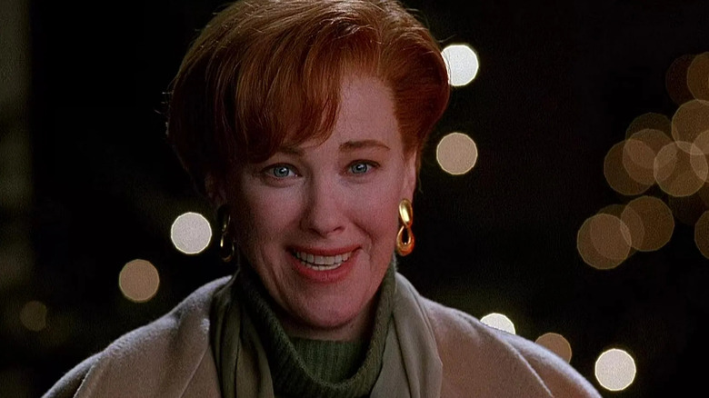 Catherine O'Hara as Kate McAllister standing in front of fuzzy Christmas lights in Home Alone 2: Lost in New York