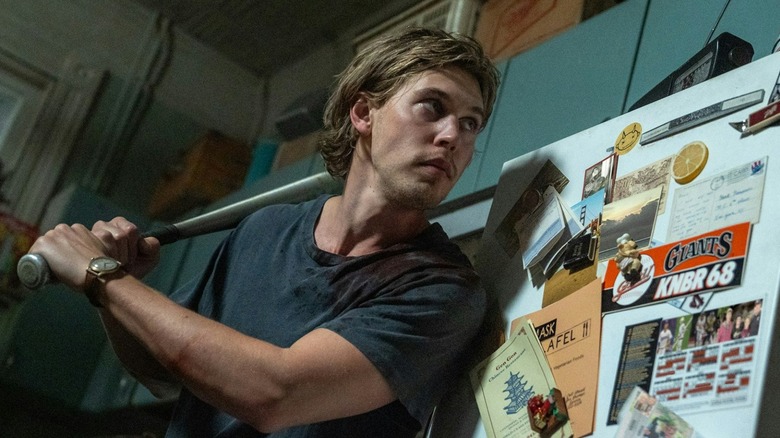 Austin Butler as Hank holding a baseball bat in his apartment in Caught Stealing