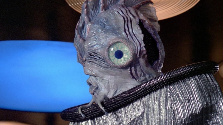 The Antedean dignitary (Mick Fleetwood) stands in the transporter room in Star Trek: The Next Generation