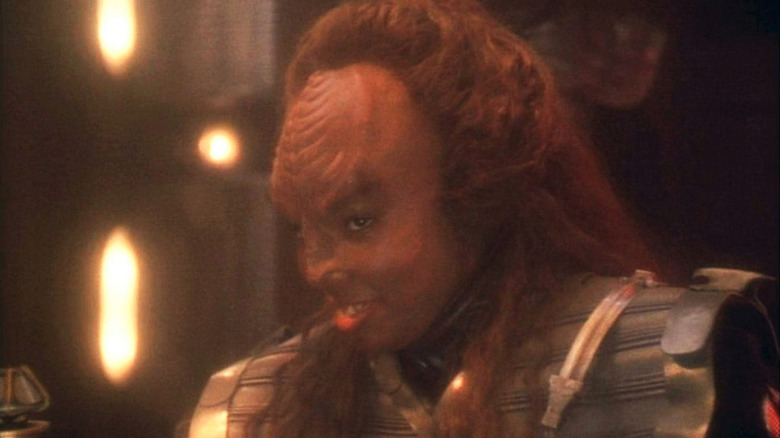 N'Garen (Gabrielle Union) grins at a table in Star Trek: Deep Space Nine