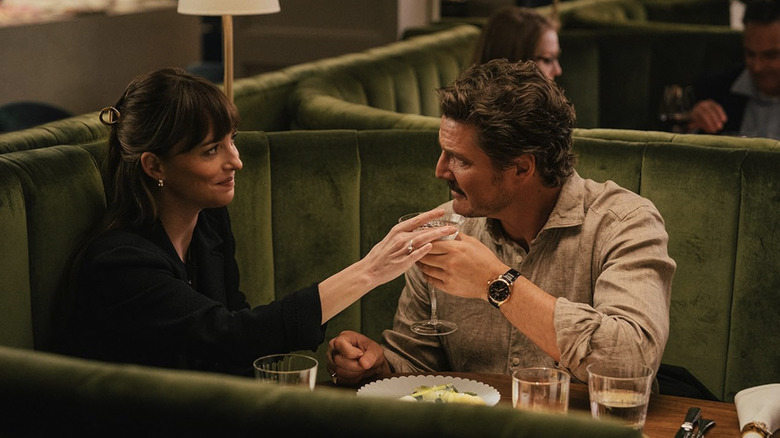 Lucy and Harry sitting at a fancy booth in Materialists