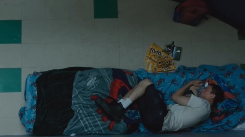 Jeffrey Manchester sleeping on top of a Spider-Man sleeping bag in Roofman