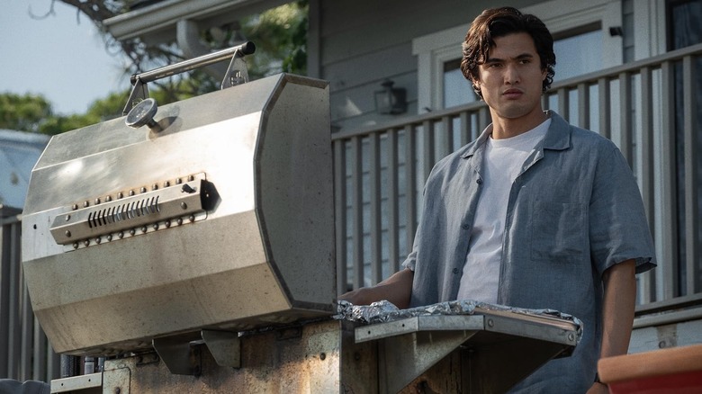 Charles Melton as Joe Yoo cooking food using a grill in May December