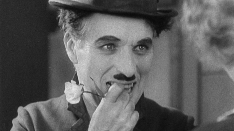The Tramp smiling with a flower in his mouth in City Lights