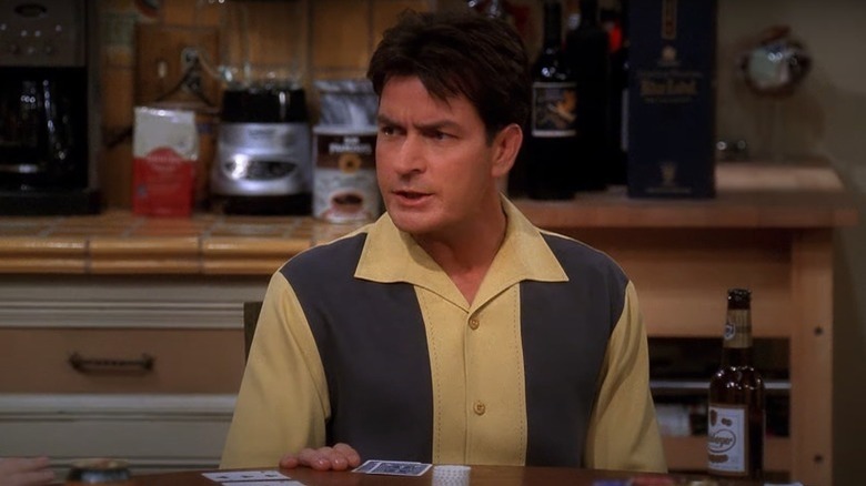 Charlie Harper sentado em uma mesa em Two and a Half Men