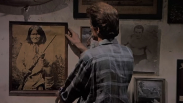 Ted Danson as Sam Malone straightening a picture of Geronimo in Cheers