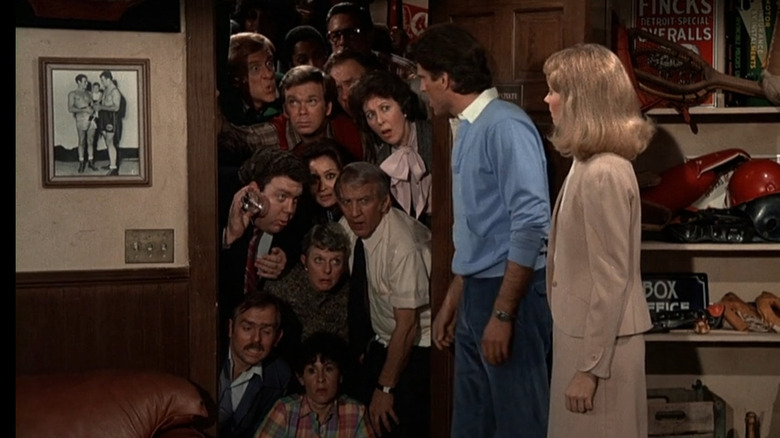 The entire bar eavesdropping on Ted Danson as Sam Malone and Shelley Long as Diane Chambers in Sam's office in Cheers