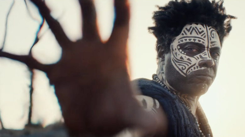 Idris Elba as Lekan raising his right palm out in Children of Blood and Bone