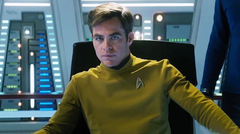 man in a yellow starfleet uniform sitting in a control room