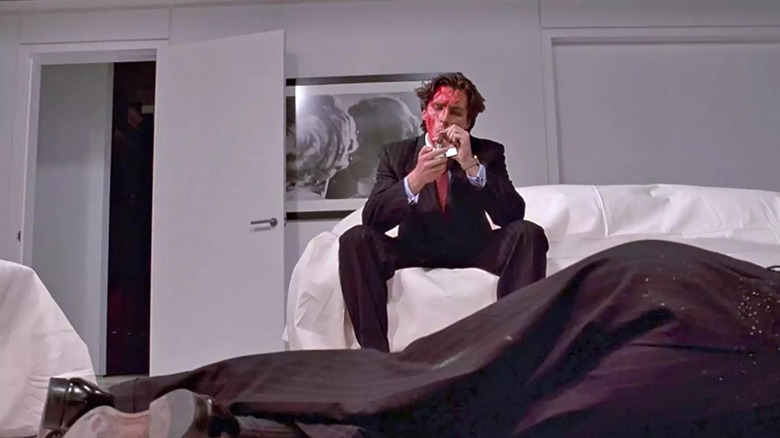 American Psycho Patrick Bateman smoking over Paul Allen's corpse