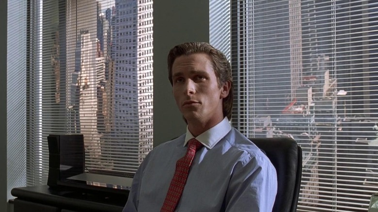 American Psycho bale sitting at desk