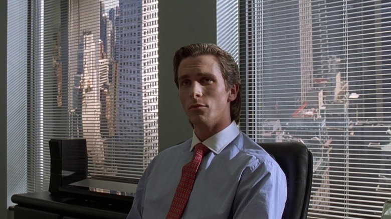 American Psycho bale sitting at desk