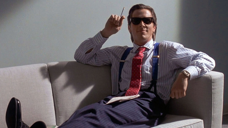 American Psycho Christian Bale on sofa with sunglasses