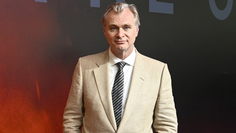 Christopher Nolan in a tan suit at the Oppenheimer premiere