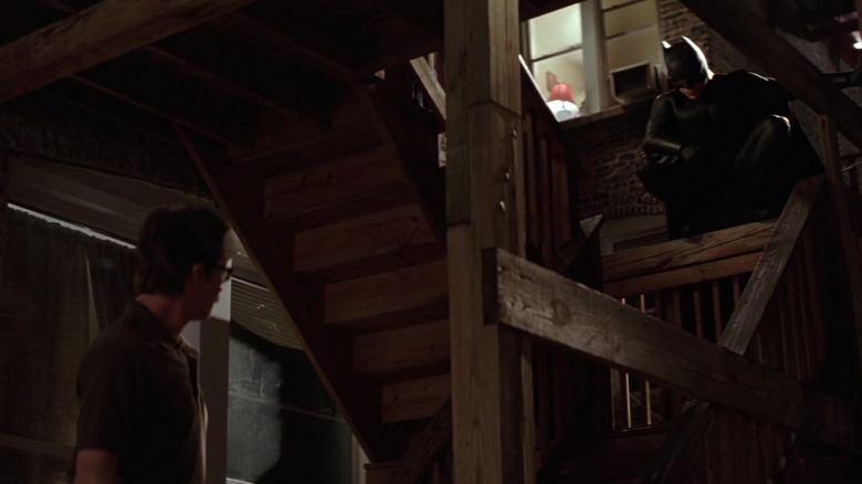 Gary Oldman sebagai Jim Gordon dan Christian Bale sebagai Batman bertemu di luar gedung apartemen di Batman Begins