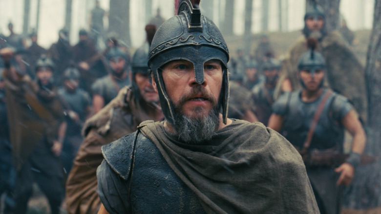 Matt Damon as Odysseus with a look of surprise on his face with his men behind him in The Odyssey