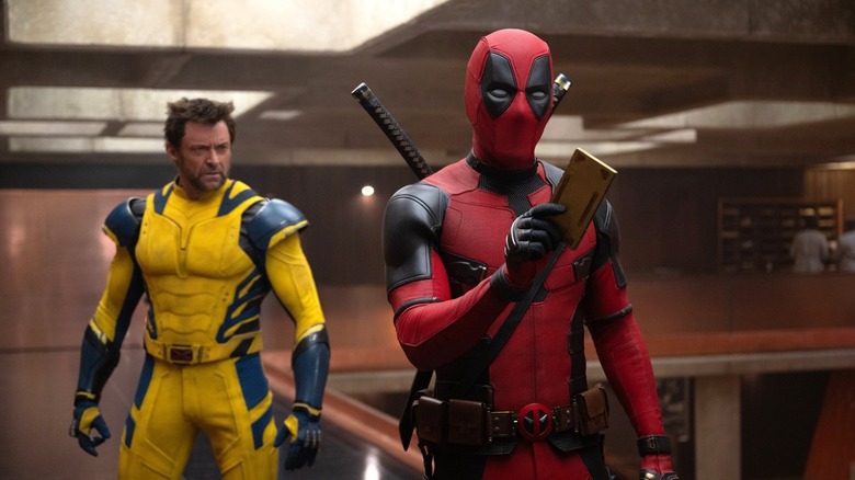 Ryan Reynolds as Deadpool in the TVA with Hugh Jackman as Wolverine standing behind him in Deadpool & Wolverine