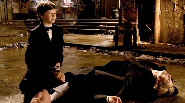 Bruce Wayne huddled next to his dead parents in Batman Begins