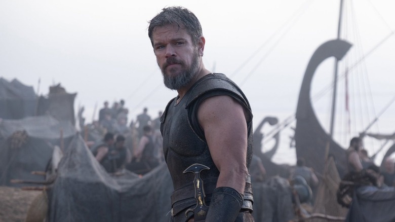 Matt Damon as Odysseus standing by his men near some boats in The Odyssey (2026)
