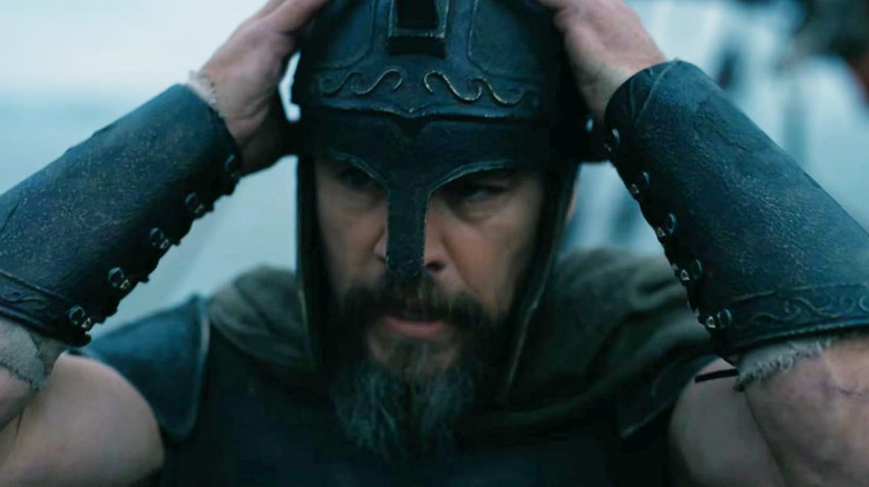 Matt Damon as Odysseus putting on his helmet in The Odyssey (2026)