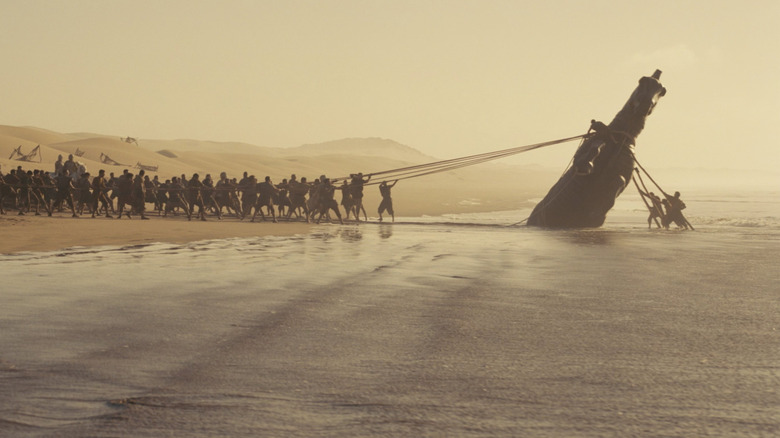 The Trojan Horse being pulled from the water in The Odyssey (2026)