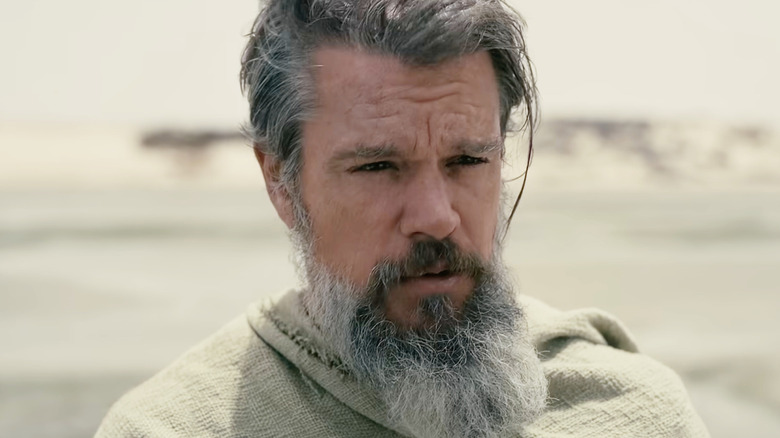Matt Damon as Odysseus with a grey beard and hair on the island of Ogygia in The Odyssey