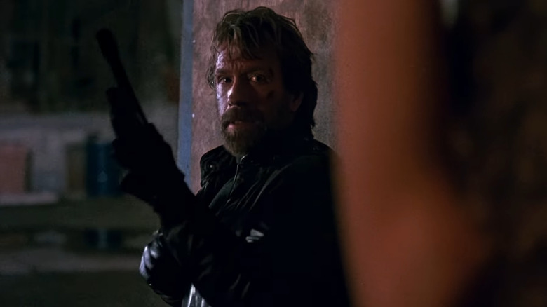 சைலன்ஸ் குறியீட்டில் ஒரு பெரிய துப்பாக்கியுடன் சார்ஜென்ட் எடி குசாக்