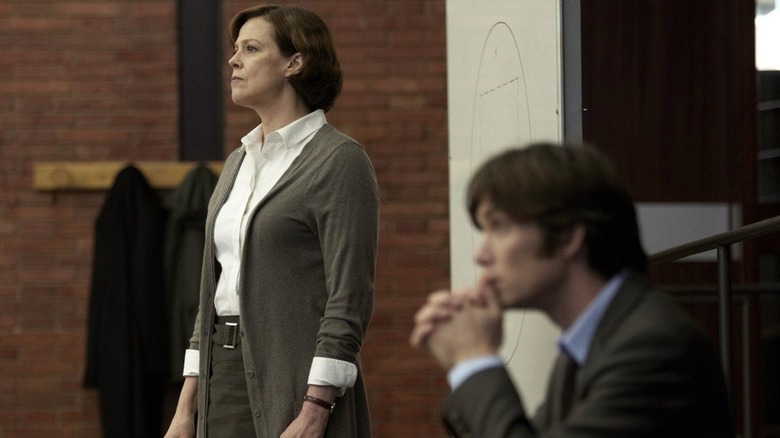 Sigourney Weaver as Professor Matheson standing and Cillian Murphy as Tom sitting in the foreground in Red Lights